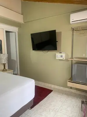a bedroom with a bed and a flat screen tv on the wall at Moradia Laureles Medellin in Medellín