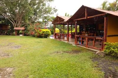 a building with a green yard with a grass field at Finca Hotel Rios Claros in San Luis
