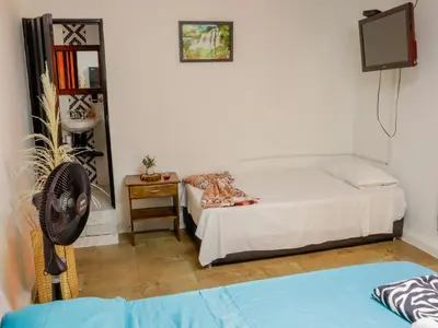 a bedroom with a bed and a fan and a tv at Finca Hotel Rios Claros in San Luis