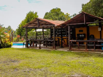 a pavilion with picnic tables next to a pool at Finca Hotel Rios Claros in San Luis