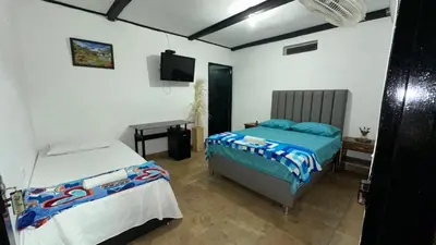 a bedroom with two beds and a television in it at Finca Hotel Rios Claros in San Luis