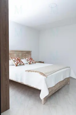 a white bedroom with a large bed with pillows at La Casa de Ana 2 in Jardin