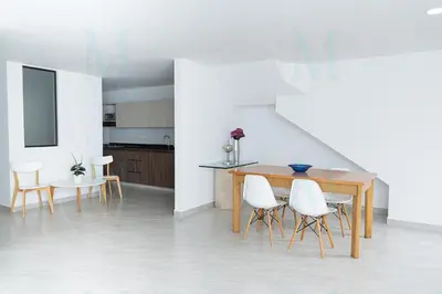 a dining room with a table and white chairs at La Casa de Ana 2 in Jardin