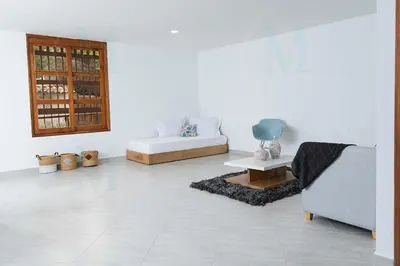 a white living room with a couch and a table at La Casa de Ana 2 in Jardin
