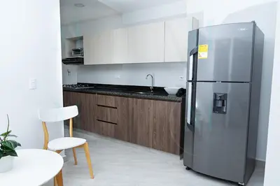 a kitchen with a stainless steel refrigerator and wooden cabinets at La Casa de Ana 2 in Jardin