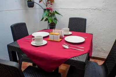 a table with a red table cloth on top of it at Hotel Boutique Estadio in Medellín