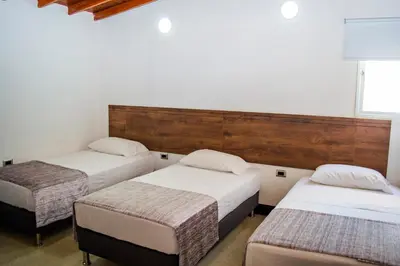 a room with three beds in a room at Hotel Boutique Estadio in Medellín