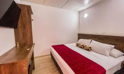 a bedroom with a bed with a red and white blanket at Hotel Boutique Estadio in Medellín