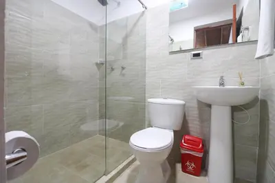 a bathroom with a toilet and a glass shower at Hotel Boutique Estadio in Medellín