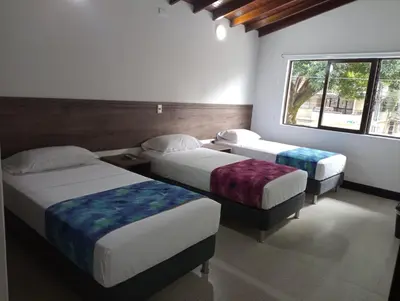 a bedroom with two beds and a window at Hotel Boutique Estadio in Medellín