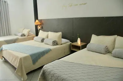 a hotel room with two beds and a sign on the wall at Hotel Capri Doradal in Doradal