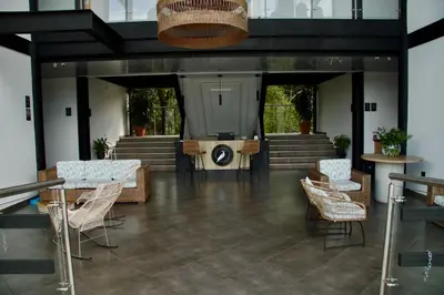 a lobby with chairs and a stage in a building at Hotel Capri Doradal in Doradal