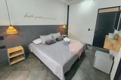 a bedroom with a bed with a pink bedspread at Hotel Capri Doradal in Doradal