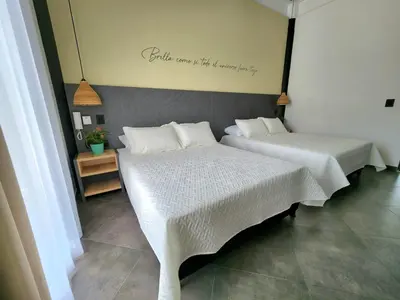 two beds sitting next to each other in a room at Hotel Capri Doradal in Doradal