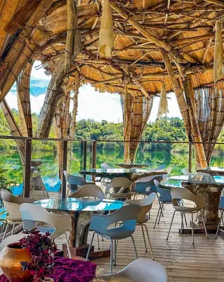 a dining room with tables and chairs in a building at Bethel Lozana Guatape in Guatapé