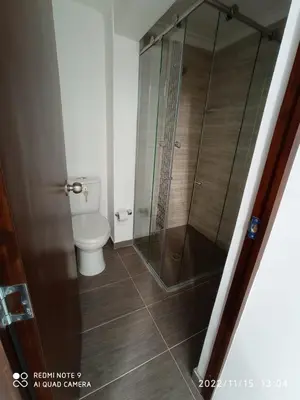 a bathroom with a toilet and a glass shower at Estadio APARTE HOTEL 203 in Medellín