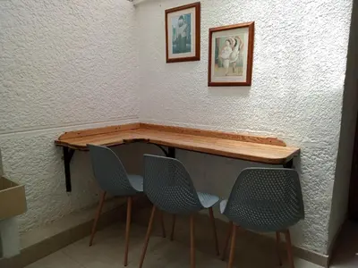 a table and chairs in a room with a wall at Estadio APARTE HOTEL 203 in Medellín