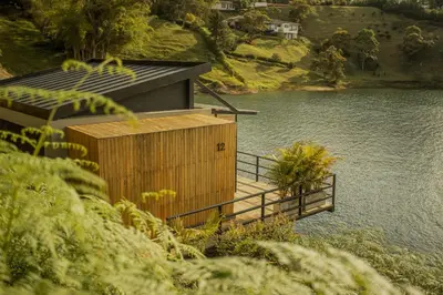 a wooden building on the side of a lake at La Pausa Hotelbistro in Guatapé