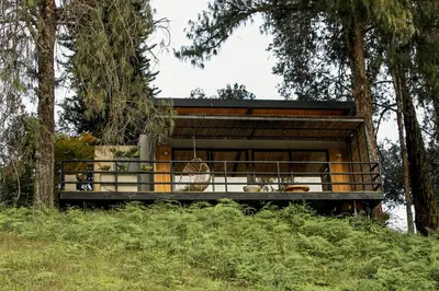 a tree house with a balcony in the woods at La Pausa Hotelbistro in Guatapé