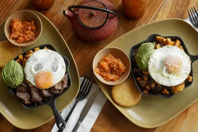 two plates of food with eggs and beans on a table at La Pausa Hotelbistro in Guatapé