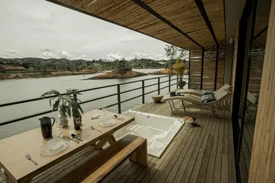 a balcony with a tub and a view of a river at La Pausa Hotelbistro in Guatapé