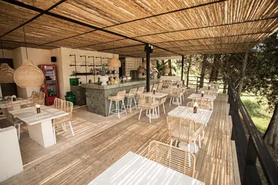 a restaurant with tables and chairs on a wooden deck at La Pausa Hotelbistro in Guatapé