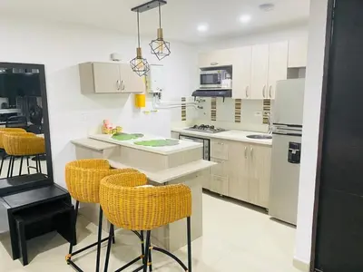a kitchen with yellow chairs and a white counter top at 1009 Apartamento zona exclusiva Poblado in Medellín