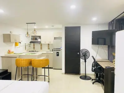 a kitchen with yellow chairs and a black refrigerator at 1009 Apartamento zona exclusiva Poblado in Medellín
