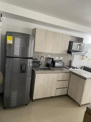 a kitchen with a stainless steel refrigerator and cabinets at 2104 Apartamento Poblado en la zona rosa de medellín in Medellín