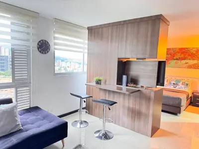 a living room with a blue couch and a bed at 2104 Apartamento Poblado en la zona rosa de medellín in Medellín