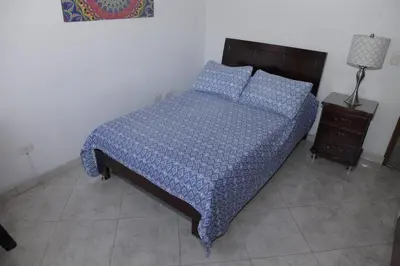 a bed with a blue comforter and pillows in a bedroom at Apartamento en Envigado in Envigado