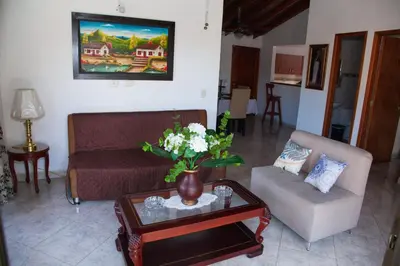 a living room with a couch and a table with flowers at Apartamento en Envigado in Envigado