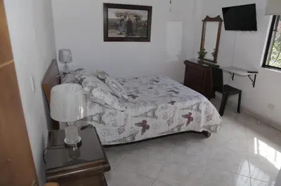 a bedroom with a bed and a table with a lamp at Apartamento en Envigado in Envigado