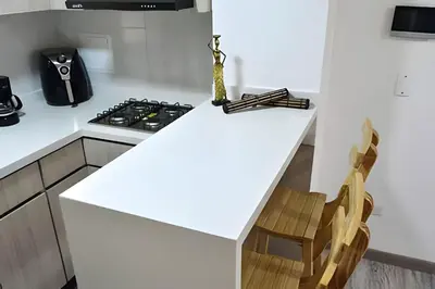a white kitchen with a counter and a stove at Espectacular Apto Zona Rosa - Milán Estrato 5 in Manizales