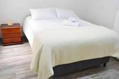 a bedroom with a white bed and a night stand at Espectacular Apto Zona Rosa - Milán Estrato 5 in Manizales