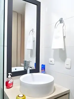a white bathroom with a sink and a mirror at Espectacular Apto Zona Rosa - Milán Estrato 5 in Manizales