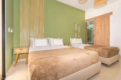 two beds in a room with green walls at La Casona Hotel Boutique in Medellín