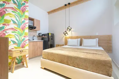 a bedroom with a bed and a kitchen at La Casona Hotel Boutique in Medellín