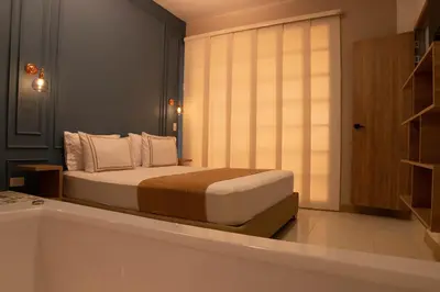 a bedroom with a bed in a room with a window at La Casona Hotel Boutique in Medellín