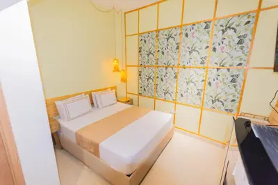 a small room with a bed and a tv at La Casona Hotel Boutique in Medellín