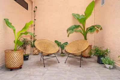 a patio with three chairs and potted plants at La Casona Hotel Boutique in Medellín