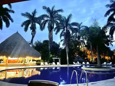 a resort swimming pool with palm trees in the background at Finca Hotel Guadalupe in Santa Fe de Antioquia