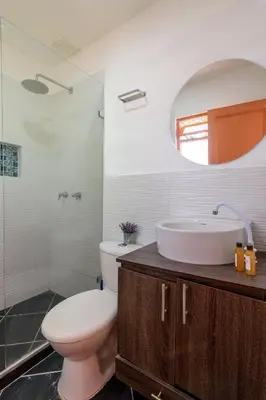 a bathroom with a toilet and a sink and a mirror at Finca Hotel Guadalupe in Santa Fe de Antioquia