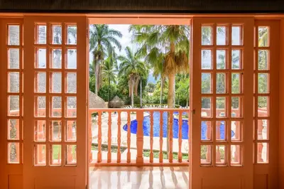 an open door to a balcony with palm trees at Finca Hotel Guadalupe in Santa Fe de Antioquia