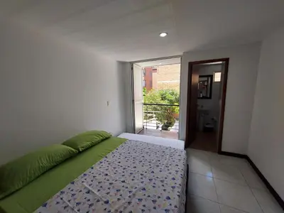 a bedroom with a bed and a door to a balcony at Apartamento Laureles la 33 in Medellín