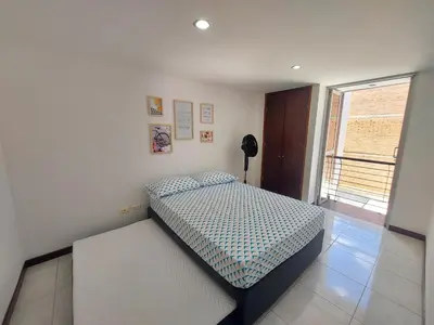 a bedroom with a bed in a room with a window at Apartamento Laureles la 33 in Medellín