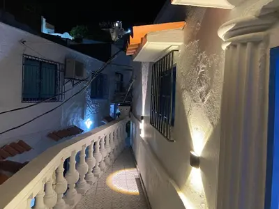 a white building with a balcony at night at Las 4 Estaciones Alojamientos de Ensueño Santorini Doradal in Puerto Triunfo