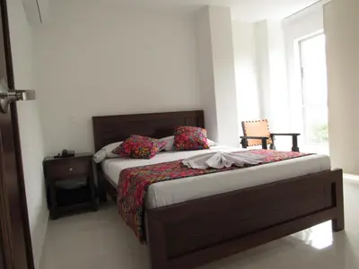 a small bedroom with a bed and a window at Hotel Plaza Berlín in Medellín