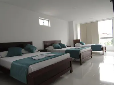 a bedroom with two beds and a window at Hotel Plaza Berlín in Medellín