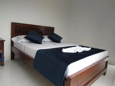 a bedroom with a large bed with blue pillows at Hotel Plaza Berlín in Medellín